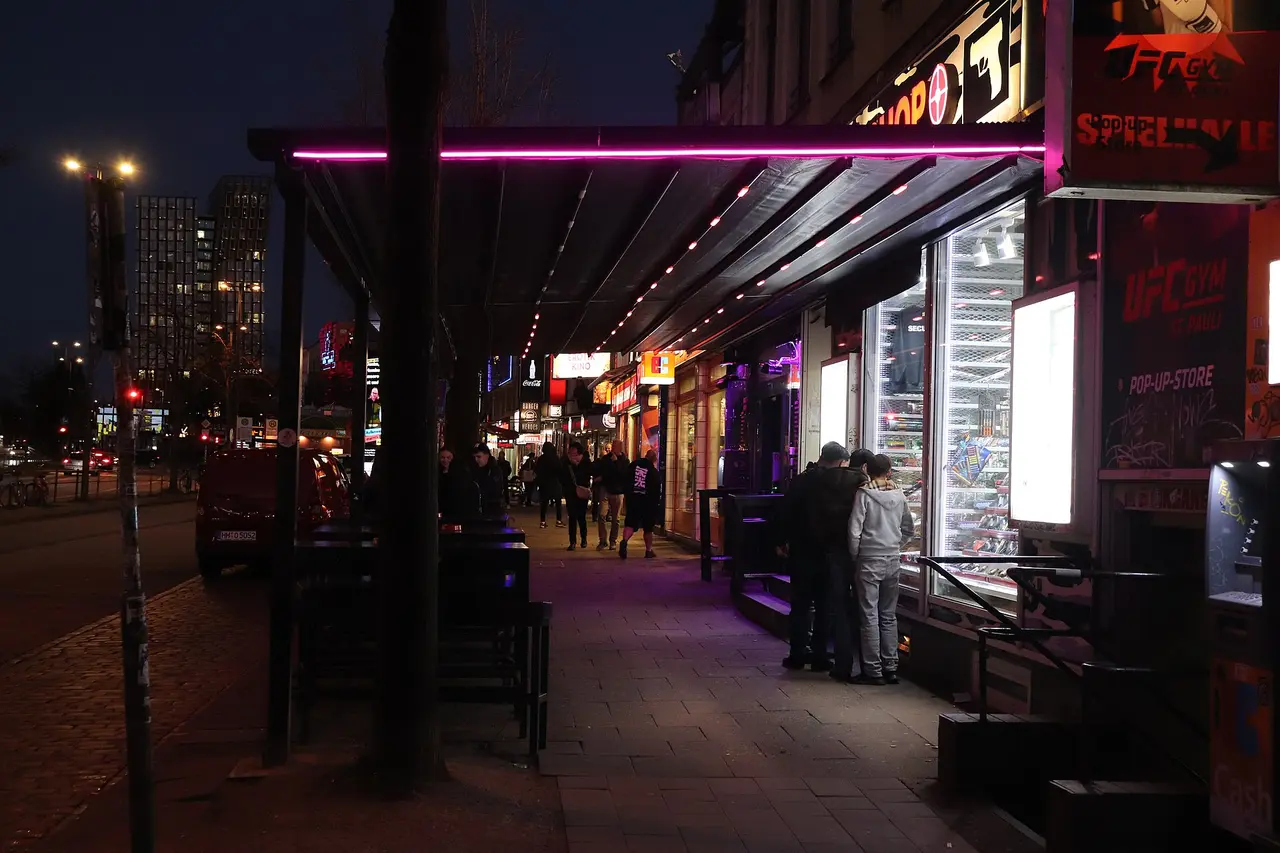 The Reeperbahn in St. Pauli in the evening, with neon light above the pavement